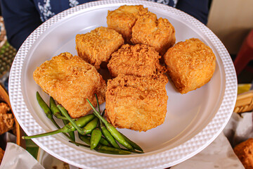 Close up of Kalasan tofu on a white plastic plate ready to eat