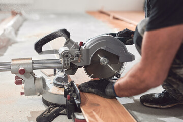 Professional handyman installing laminate flooring in a new apartment.