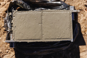 Technician worker checking of concrete quality during cube test on building site