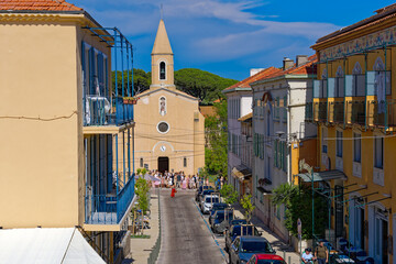 Beautiful Mediterranean village with restaurants, church and  wedding party in bright sunlight at...