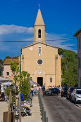Fototapeta na wymiar Beautiful Mediterranean village with restaurants, church and wedding party in bright sunlight at Giens peninsula on a sunny spring day. Photo taken June 10th, 2023, Giens, Hyères France.