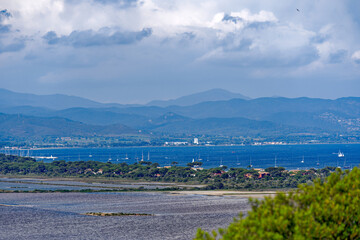 Fototapeta na wymiar Aerial view of Giens Peninsula with saline on a sunny spring day with Mediterranean Sea and mountain panorama in the background. Photo taken June 10th, 2023, Giens, France.