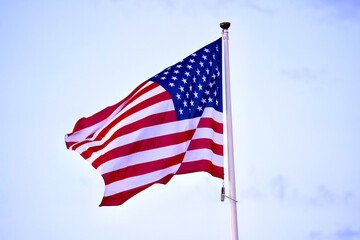 Waving USA flag at fun park at Giens peninsula on a cloudy spring evening. Photo taken June 10th, 2023, Giens, France.
