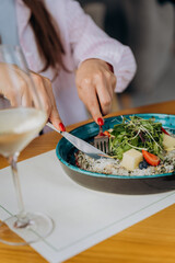 Close up of woman eating beef carpaccio with pesto sauce and parmigiano cheese. Restaurant menu