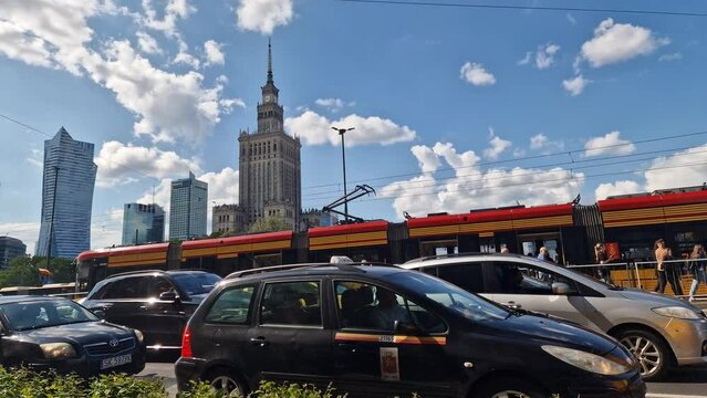 Warsaw, Poland, July 27, 2023: time lapse. city traffic during rush hour with lots of cars, trams, buses moving fast in time. Palace of Science and Culture in Warsaw, Poland