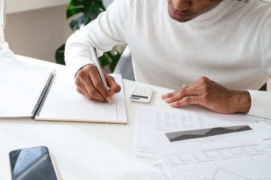 Young businessman sitting at desk and working on documents in home office