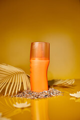 Sunscreen tube mockup with shells, sand yellow background, summer vacations and spf uv-protecting skin care concept, hard light.