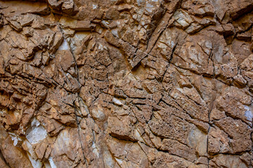 Natural rock texture background. Rocky bas-relief wall.