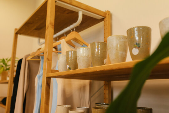 Handmade clay glasses arranged on shelf in store