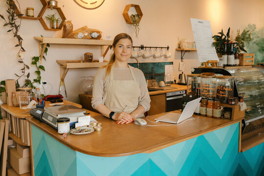 Blond owner standing at counter in cafe