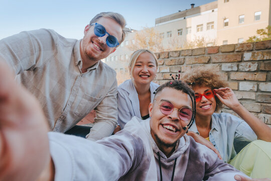 Smiling man taking selfie with friends on rooftop