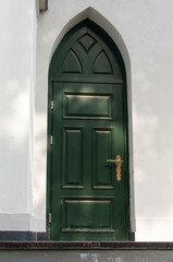 Green door with a golden handle of St. John's Lutheran Church in Grodno.