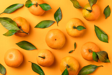 Juicy mandarins with leaves on orange background top view wallpaper poster card