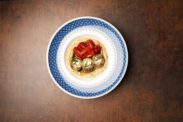 Vegan meal plate with fresh tomatoes, mashed potato and stuffed eggplant