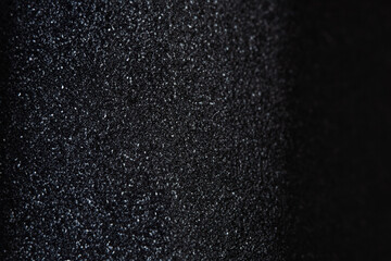 Texture of rough black plastic. Close up detail, ultramacro photo of dark textured material patterns. Graphic level, black asphalt.