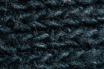 Texture of black woolen fabric. Close up photo, ultra macro magnification of intertwined wool fibers. Detail, tufts of thread, graphic material.