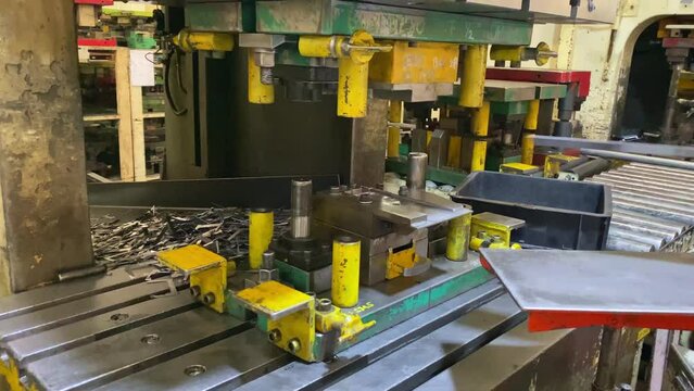 Hand of people work on the hydraulic press machine. Hydraulic press stamping machine for forming metal sheet, Industrial metalwork manufacturing.