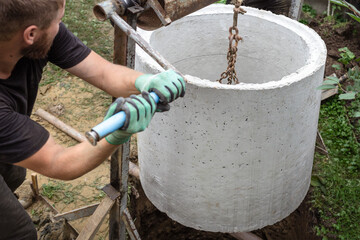 Septic Tank Installation. Installing Concrete Rings into Excavated Pit for Septic Tank.