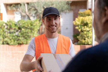 closeup of a young attractive man delivering packages at the door of home