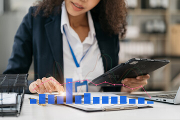 Businesswoman working with tablet and using a calculator to calculate the numbers of static in...
