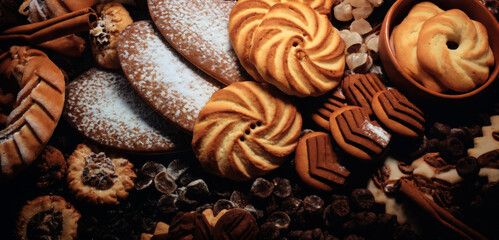 background from the assortment of cookies with chocolate on a wooden table, delicious pastries - obrazy, fototapety, plakaty