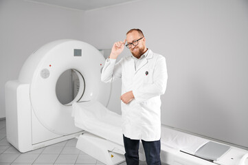 Portrait of smiling doctor with medical computed tomography or MRI scanner. Concept of medicine,...