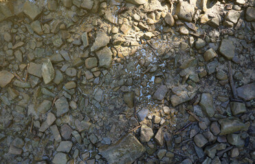 Background of shattered stony stones surface in mountain area. Flat texture with natural light