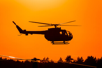 Fototapeta na wymiar HELICOPTER - Machine against the background of sky with the sunset
