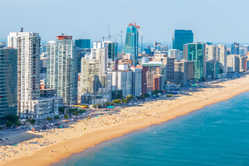 Naklejka premium city ​​beach. big city with high-rise buildings, beach on the seashore, view from above. summer vacation concept