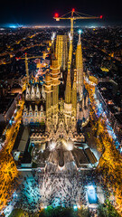 Aerial view of La Sagrada Família in the night. Spanish basilica in Barcelona. Drone footage of the cathedral designed by Antoni Gaudí. - obrazy, fototapety, plakaty