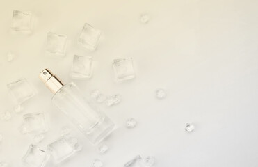 Female perfume bottle, objective photograph of perfume bottle in ice cubes and water. view from above. product photo, concept of freshness and aroma
