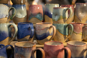 tea mugs made of glazed ceramics are sold at the crafts fair
