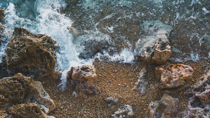 Waves breaking into the rocks during sunset