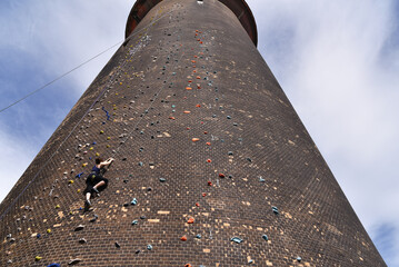 Couples climbing outside on an artificial wall at a tower - climbing sport