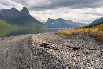 Majestic mountains by the calm sea on a beautiful summer afternoon, Lyngen Alps, Northern Norway