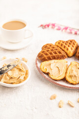 Homemade waffle with peanut butter on a gray concrete. side view, selective focus.