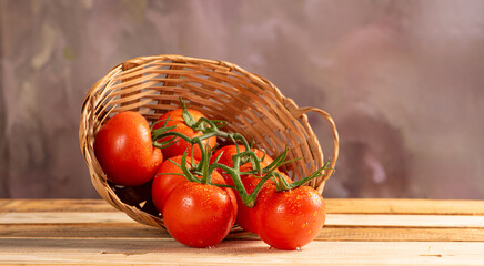 Tomatoes, beautiful arrangement with tomatoes in a basket on rustic wood, selective focus.