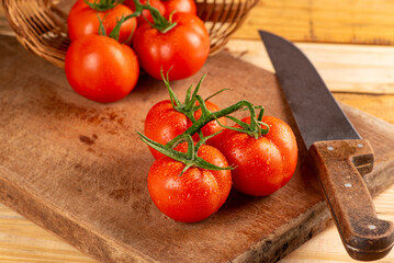 Tomatoes, beautiful arrangement with tomatoes in a basket on rustic wood, selective focus.