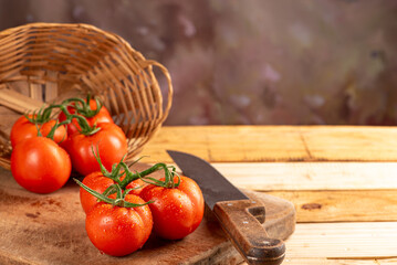 Tomatoes, beautiful arrangement with tomatoes in a basket on rustic wood, selective focus.