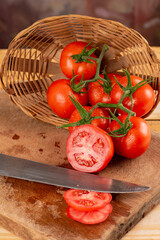 Tomatoes, beautiful arrangement with tomatoes in a basket on rustic wood, selective focus.