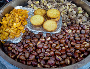 fried potato pancakes, baked potatoes and chestnuts in a large pot at a food festival

