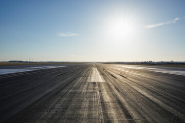 Surface level of long airport runway with directional marking against clear sky. . - obrazy, fototapety, plakaty