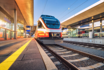 High speed train on the modern railway station at sunset in summer in Graz, Austria. Beautiful...