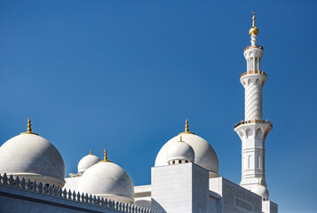 Fototapeta na wymiar Domes and minarets of Sheikh Zayed Grand Mosque built with white marble stone. Abu Dhabi, UAE - 8 February, 2020