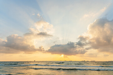 beautiful seascape of sunset with dramatic cloudy sky and ships on horizon line