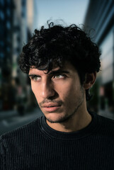 A man with curly hair standing in a city