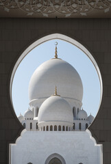 Fototapeta na wymiar Dome of Sheikh Zayed Grand Mosque photographed through the arc at the entrance. Abu Dhabi, UAE - 8 February, 2020