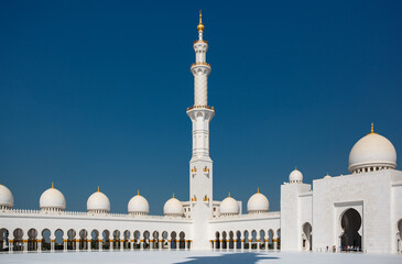 Tall minaret tower of the Sheikh Zayed Grand Mosque built with white marble stone. Abu Dhabi, UAE - 8 February, 2020