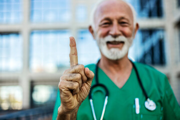 Mature man, doctor and hand for healthcare, health insurance and medical care for wellness. Finger or a medical professional as expert in medicine and healing with pride for development and advice.