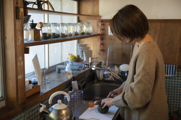 田舎で丁寧な暮らしをする中年女性 キッチンで料理 コピースペースあり - obrazy, fototapety, plakaty